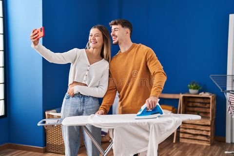Young Man And Woman Couple Ironing Clothes Make Selfie By The Smartphone At Laundry Room Stock ... throughout The Hardworking Laundry: How To Make Room For Ironing